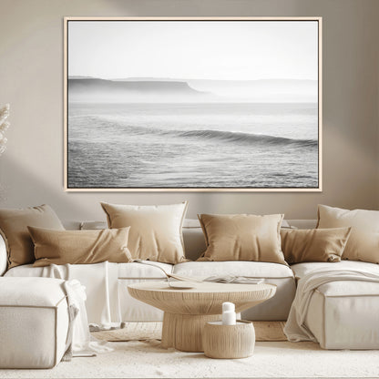 A black and white minimalist seascape featuring soft rolling waves and misty distant cliffs, creating a serene and timeless coastal atmosphere.
