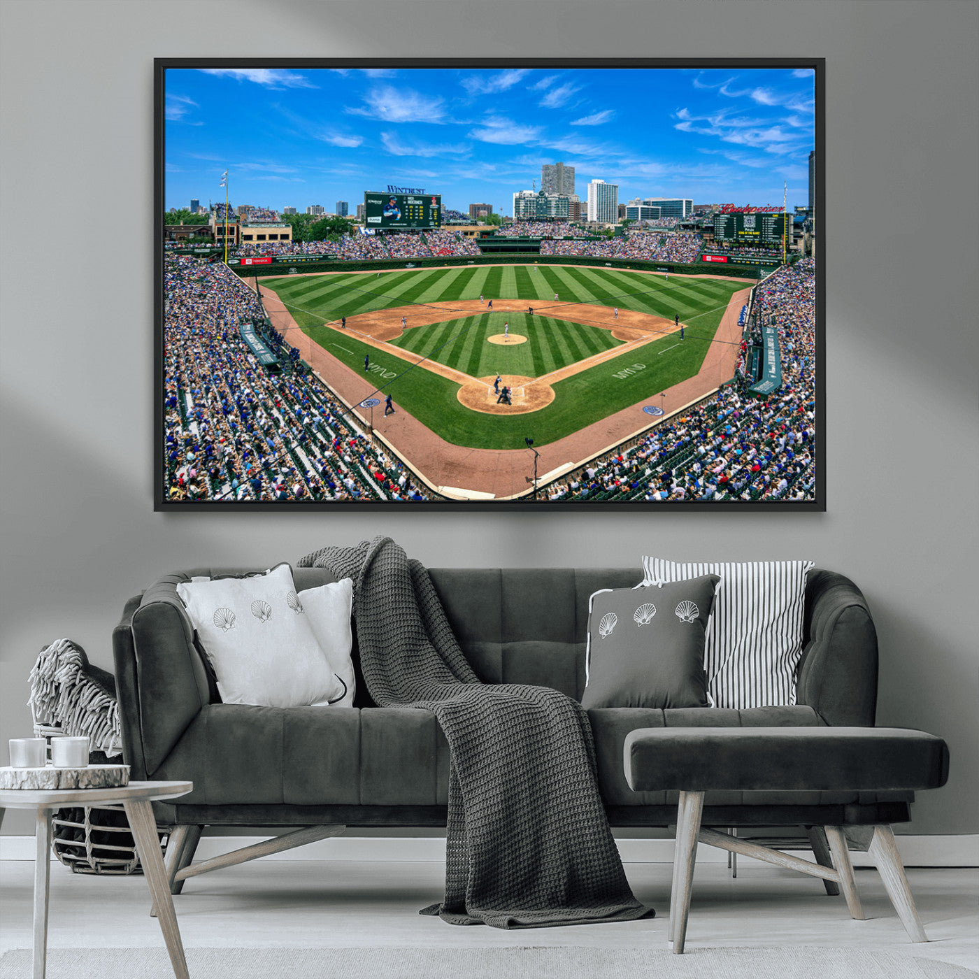 A wide-angle shot of a baseball field filled with spectators, with players on the field and the iconic Wrigley Field scoreboard in the background.