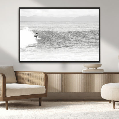 Monochrome photo of a surfer riding a wave with distant mountains, ideal for coastal motion or black and white surf-themed wall decor.