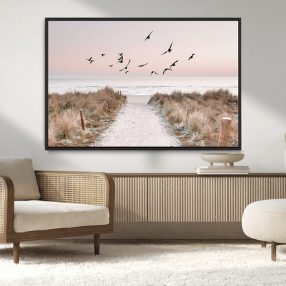 A peaceful coastal pathway leading to the ocean, with birds flying across a soft pastel sky, creating a calm and scenic beach atmosphere.