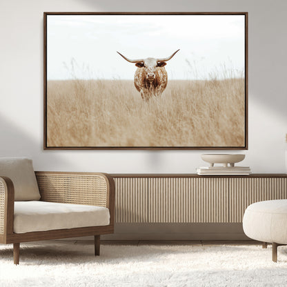 Texas Longhorn bull standing alone in dry grass with neutral tones, ideal for rustic western or cowboy-themed wall decor.
