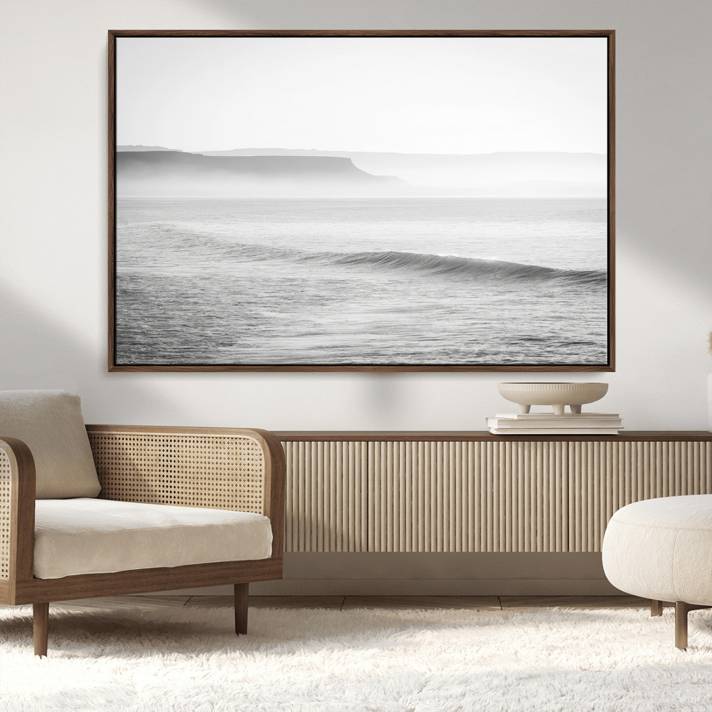 A black and white minimalist seascape featuring soft rolling waves and misty distant cliffs, creating a serene and timeless coastal atmosphere.