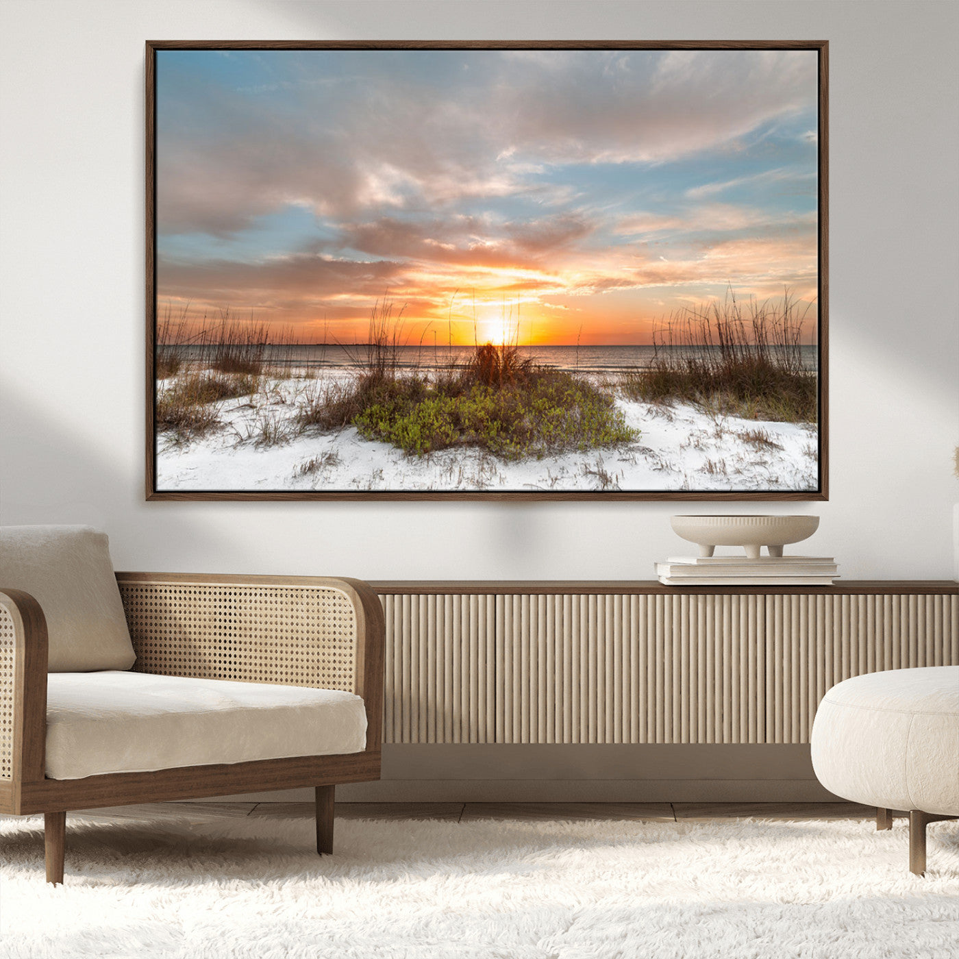 A tranquil beach scene featuring golden sunset hues over the water, with grasses in the foreground and a peaceful, serene atmosphere.