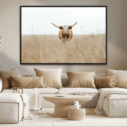 Texas Longhorn bull standing alone in dry grass with neutral tones, ideal for rustic western or cowboy-themed wall decor.