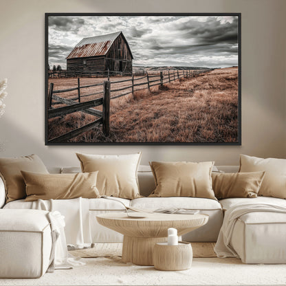 Framed canvas of a rustic barn under a moody sky with weathered fence and dark fields, ideal for farmhouse or rural-style wall decor.