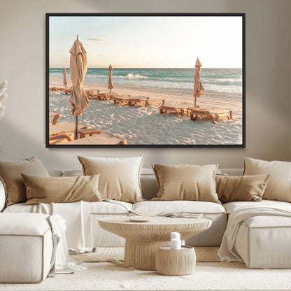 Minimalist photo of empty beach loungers and umbrellas on soft sand, ideal for calm seaside or pastel coastal-style home decor.