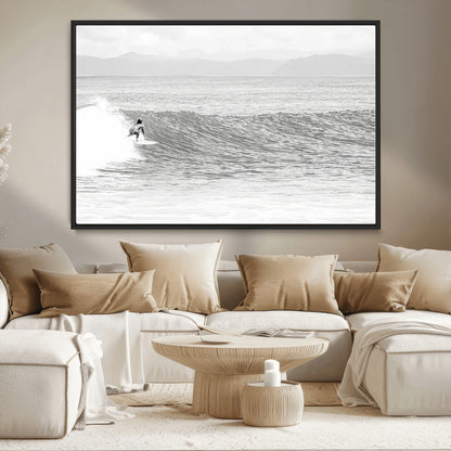 Monochrome photo of a surfer riding a wave with distant mountains, ideal for coastal motion or black and white surf-themed wall decor.