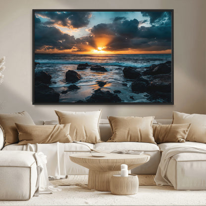 An awe-inspiring sunset over the ocean with rays of light piercing through dramatic clouds, creating a beautiful seascape with rocks in the foreground.
