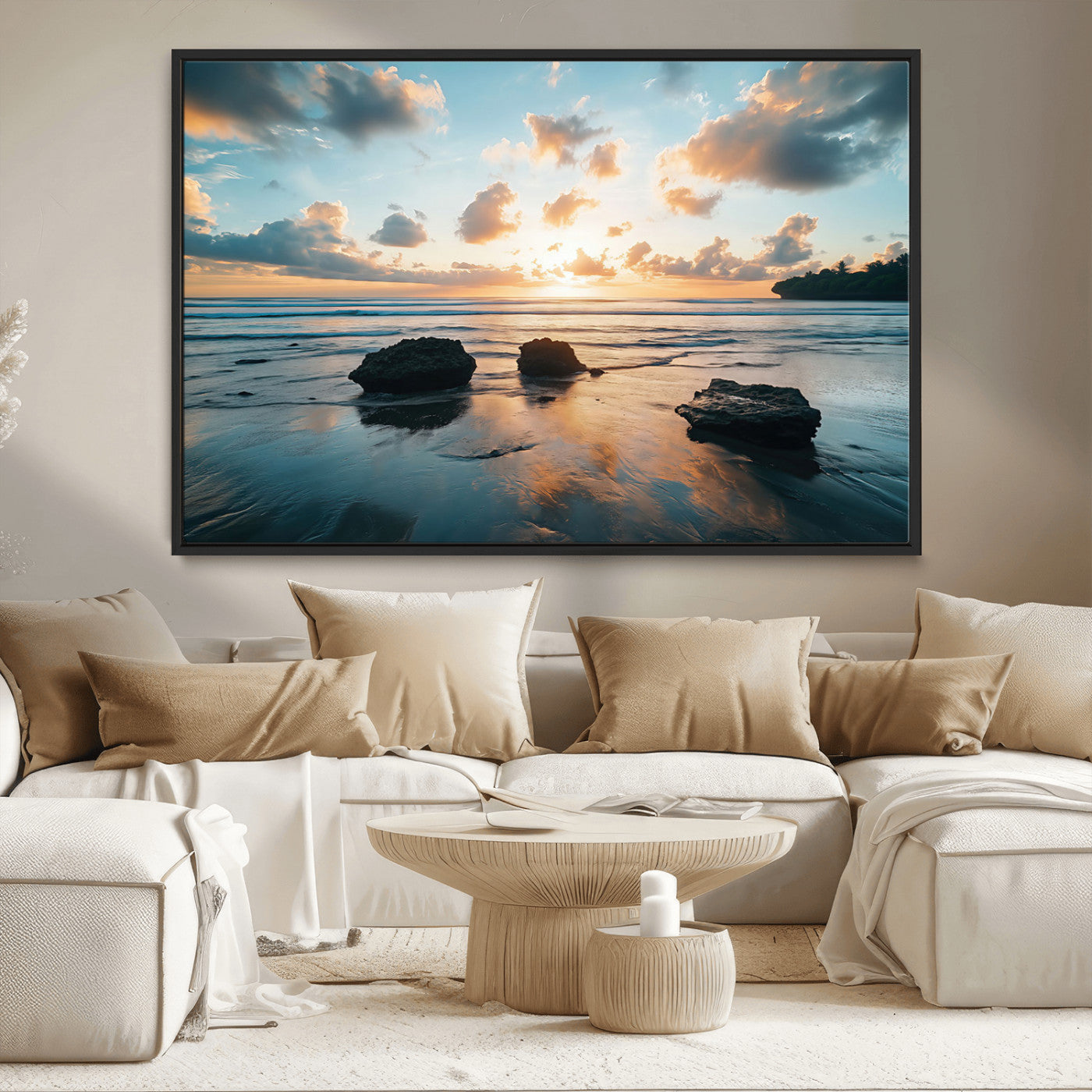 A serene beach at sunset with vibrant clouds, calm water, and rocks in the foreground reflecting the warm colors of the setting sun.