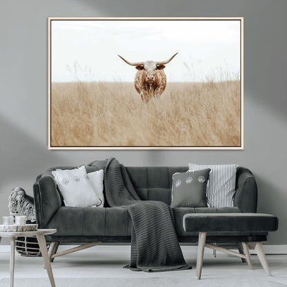 Texas Longhorn bull standing alone in dry grass with neutral tones, ideal for rustic western or cowboy-themed wall decor.