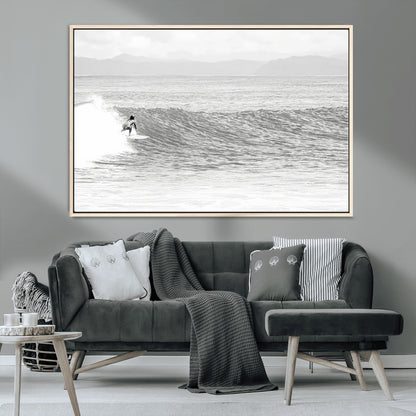 Monochrome photo of a surfer riding a wave with distant mountains, ideal for coastal motion or black and white surf-themed wall decor.
