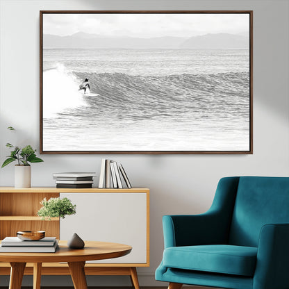 Monochrome photo of a surfer riding a wave with distant mountains, ideal for coastal motion or black and white surf-themed wall decor.