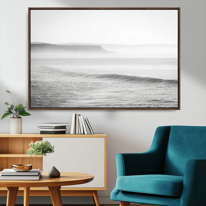 A black and white minimalist seascape featuring soft rolling waves and misty distant cliffs, creating a serene and timeless coastal atmosphere.