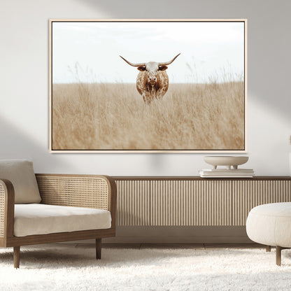 Texas Longhorn bull standing alone in dry grass with neutral tones, ideal for rustic western or cowboy-themed wall decor.