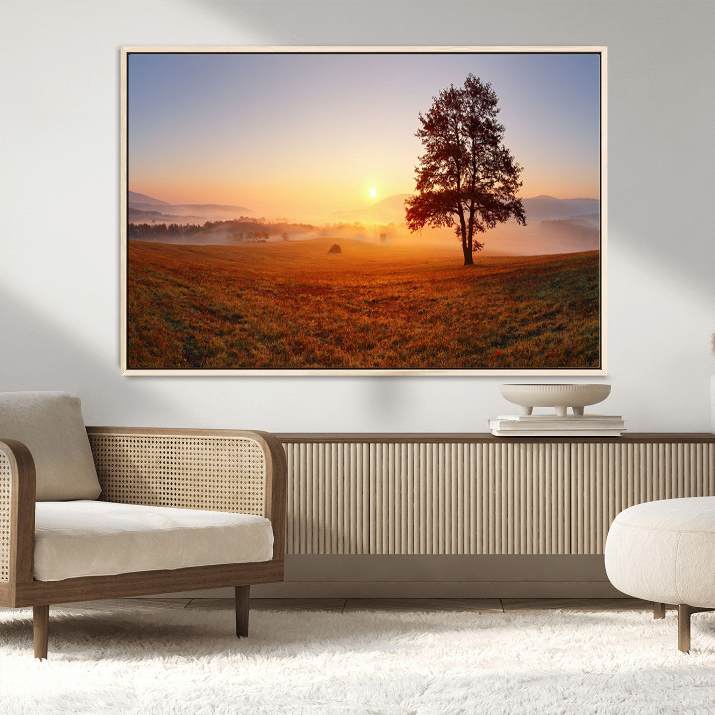 A tranquil landscape at sunrise with a mist-covered field and a lone tree, creating a peaceful and natural atmosphere.