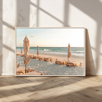 Minimalist photo of empty beach loungers and umbrellas on soft sand, ideal for calm seaside or pastel coastal-style home decor.