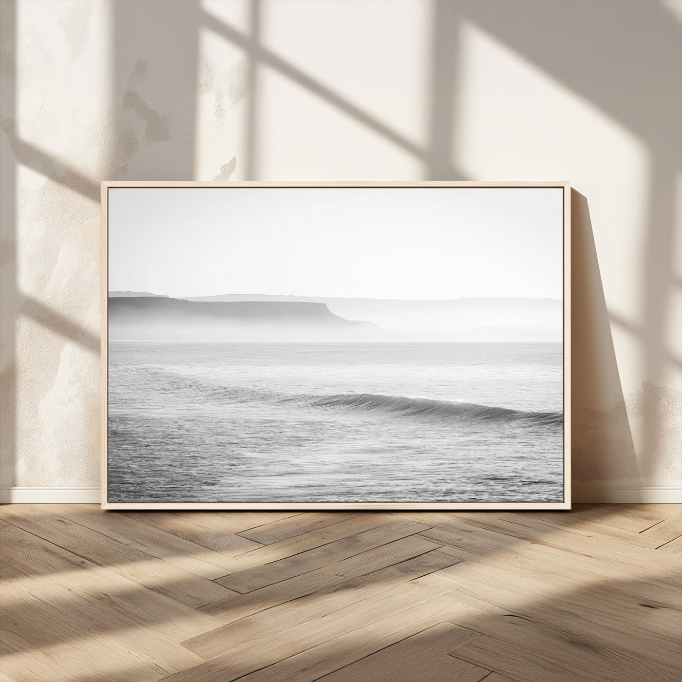 A black and white minimalist seascape featuring soft rolling waves and misty distant cliffs, creating a serene and timeless coastal atmosphere.