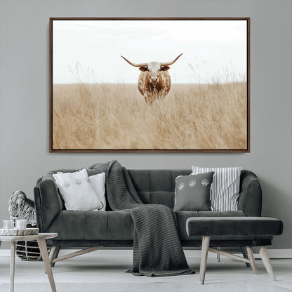Texas Longhorn bull standing alone in dry grass with neutral tones, ideal for rustic western or cowboy-themed wall decor.