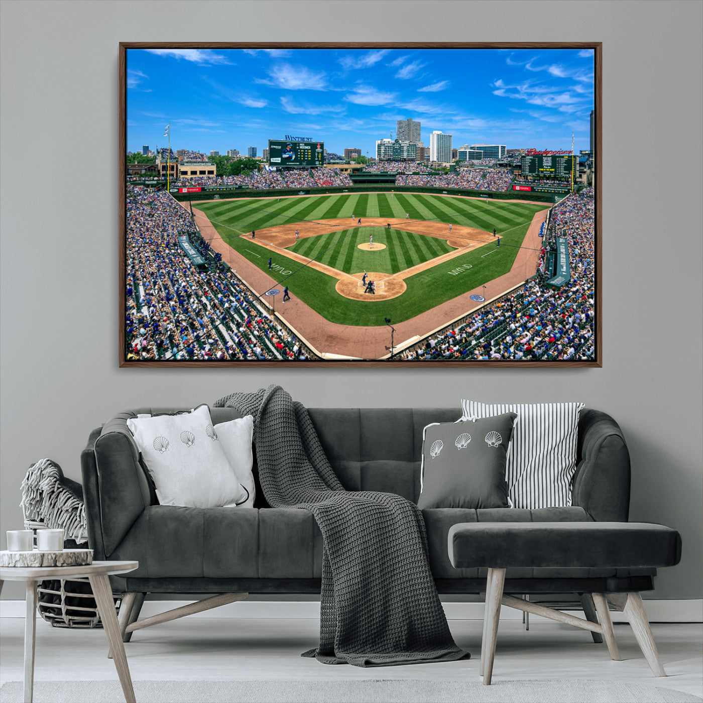 A wide-angle shot of a baseball field filled with spectators, with players on the field and the iconic Wrigley Field scoreboard in the background.