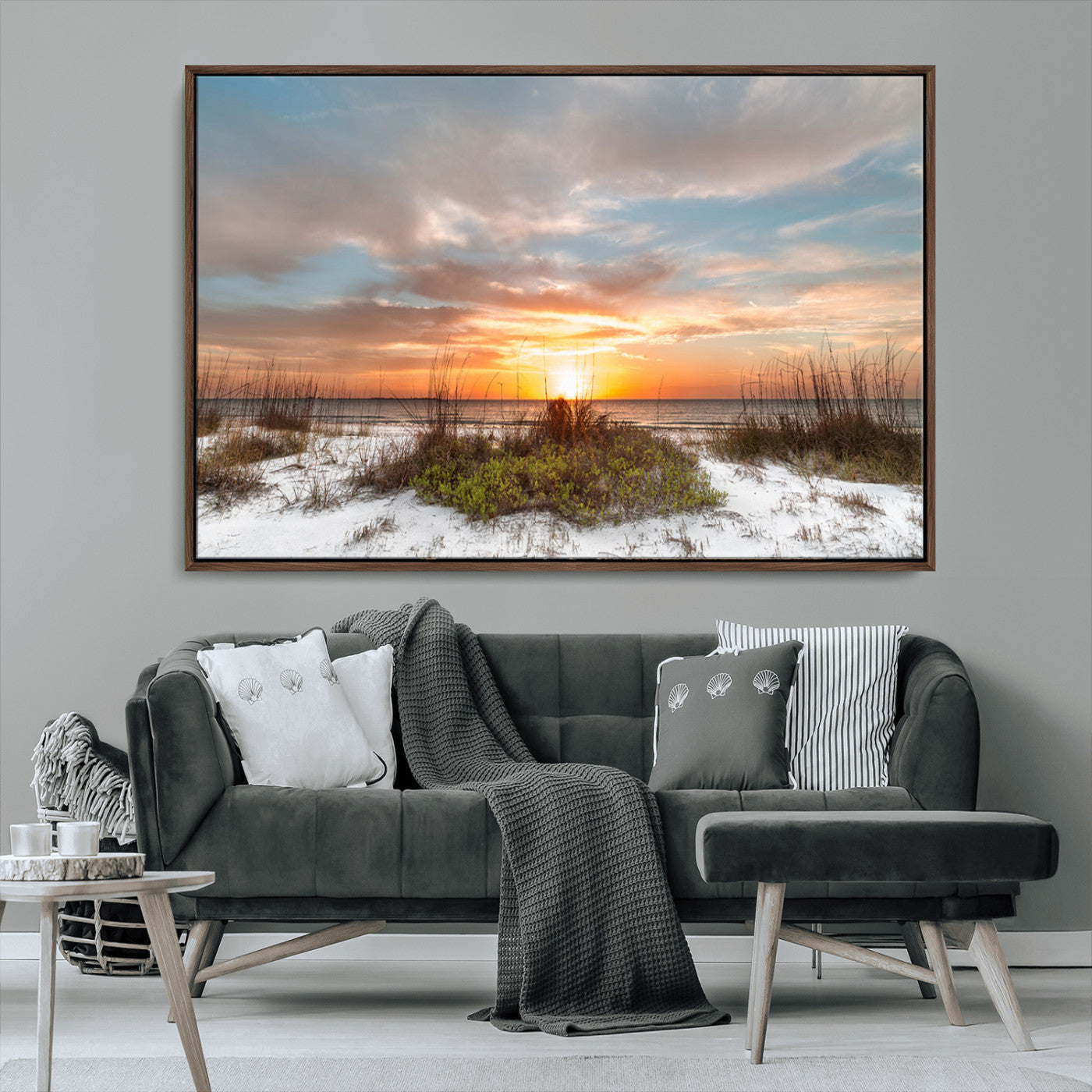 A tranquil beach scene featuring golden sunset hues over the water, with grasses in the foreground and a peaceful, serene atmosphere.