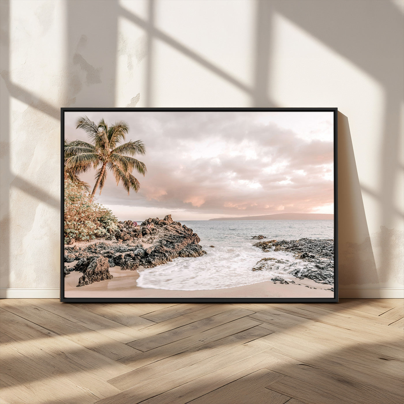 A peaceful beach scene with a palm tree and rocks, soft waves washing onto the shore under a soft pastel sky at sunset.