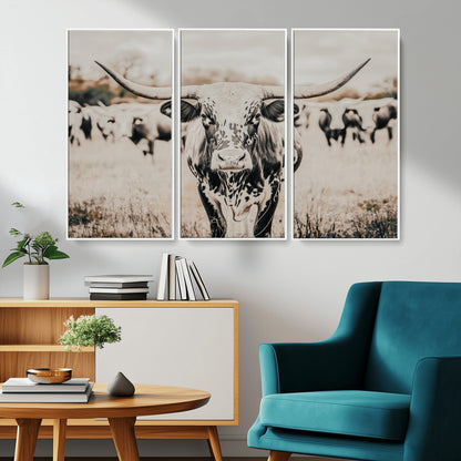 Canvas of a speckled Texas longhorn standing boldly in a field with a herd behind, perfect for rustic western or farmhouse wall decor.