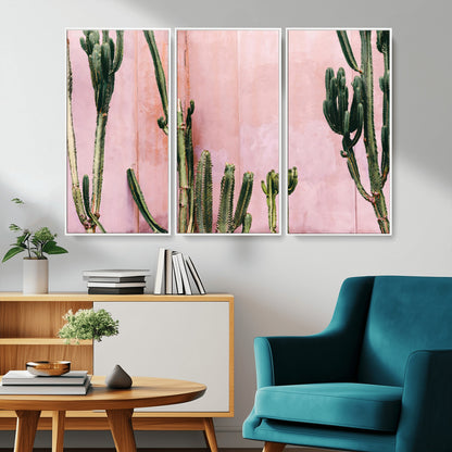 Framed canvas of tall green cacti against a soft pink wall, ideal for modern desert or colorful southwest-inspired home decor.