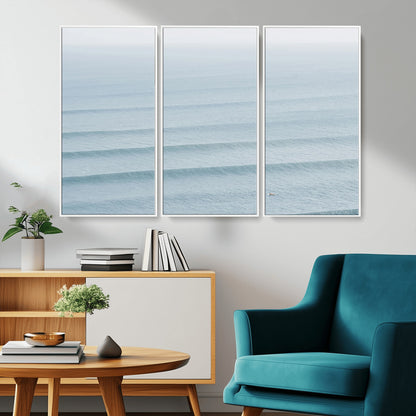 Framed canvas of repeating ocean waves with a distant solo surfer, ideal for minimalist ocean or calm coastal wall decor.