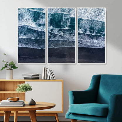 Canvas of aerial ocean waves crashing onto a black sand beach in moody tones, ideal for modern coastal or minimalist home decor.