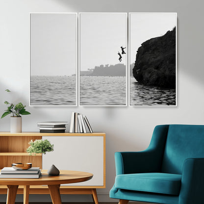 Black and white canvas of two figures cliff jumping into the sea, captured with moody tones, ideal for modern coastal or adventure-themed home decor.   2/2