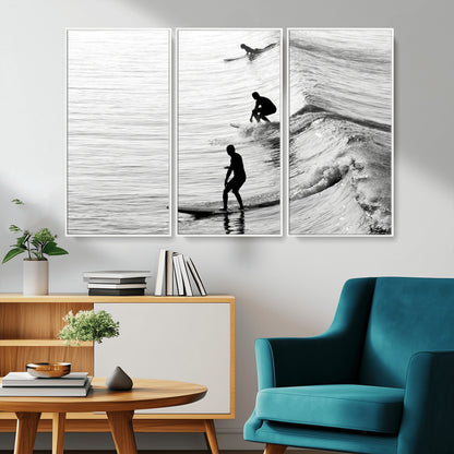 Black and white photo of surfers riding waves in a moody, high-contrast scene, ideal for modern coastal or surf-inspired home decor.