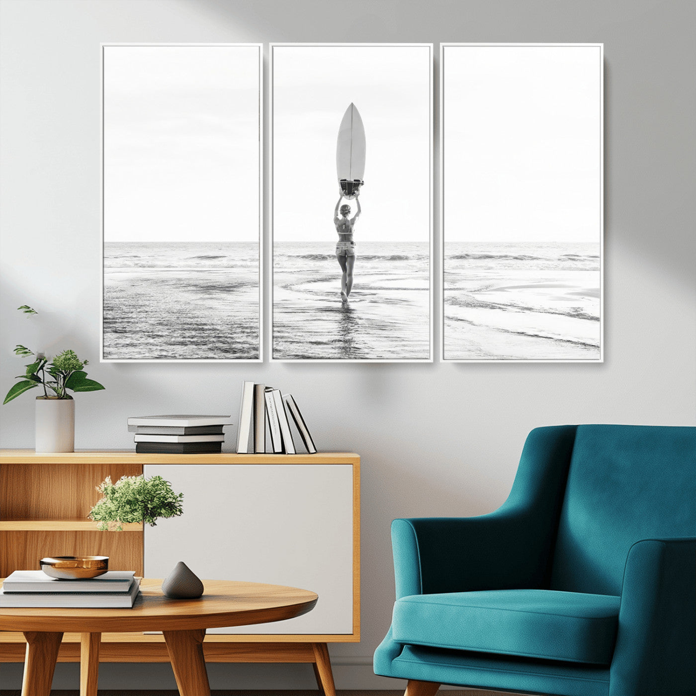 Black and white image of a female surfer holding a surfboard above her head while walking toward the ocean, creating a minimalist and bold coastal aesthetic.