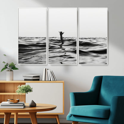 Black and white ocean with a hand making a surfer sign among dark waves, creating a dramatic and minimalist seascape with bold contrast.
