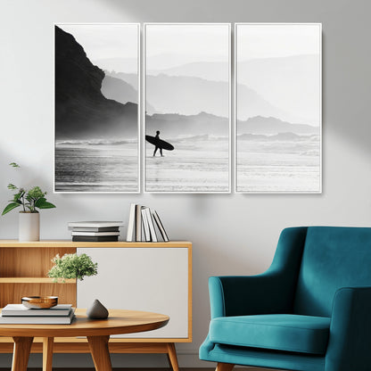 A lone surfer walking along a misty beach with cliffs in the background, carrying their board, capturing a serene and minimal ocean moment.