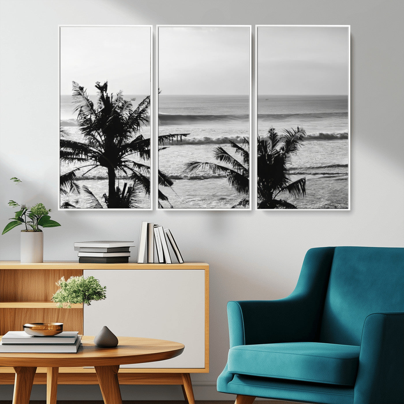 Black and white view of ocean waves crashing on a tropical coastline, framed by silhouetted palm trees under a vast, open sky.