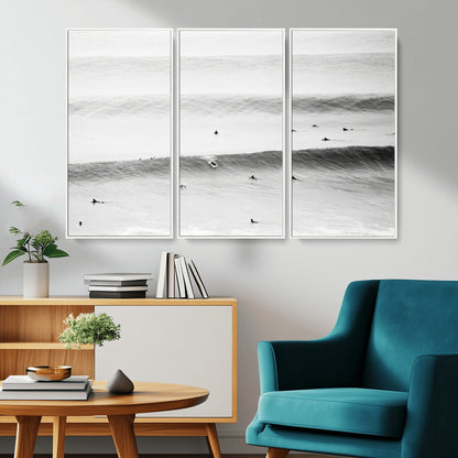 A monochrome photograph of swimmers gliding through gentle ocean waves, evoking a sense of calm and movement.