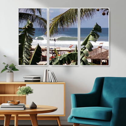 Canvas wall art of a tropical surf scene framed by palm trees, with a surfer on the shore and waves rolling in, ideal for beach-themed decor.