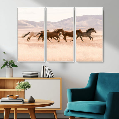 A herd of wild horses galloping through a sunlit desert plain with mountains in the background, perfect for rustic or western-themed wall decor.