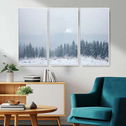 Snow-covered forest under misty sky, soft light breaking through clouds, ideal for minimalist or Nordic-inspired home decor.