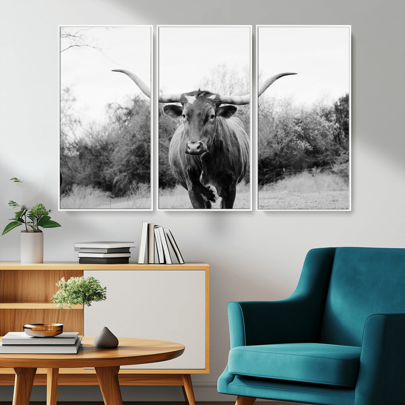 Black and white photo of a longhorn cow in a field, perfect for rustic farmhouse or western-themed interior wall decoration.