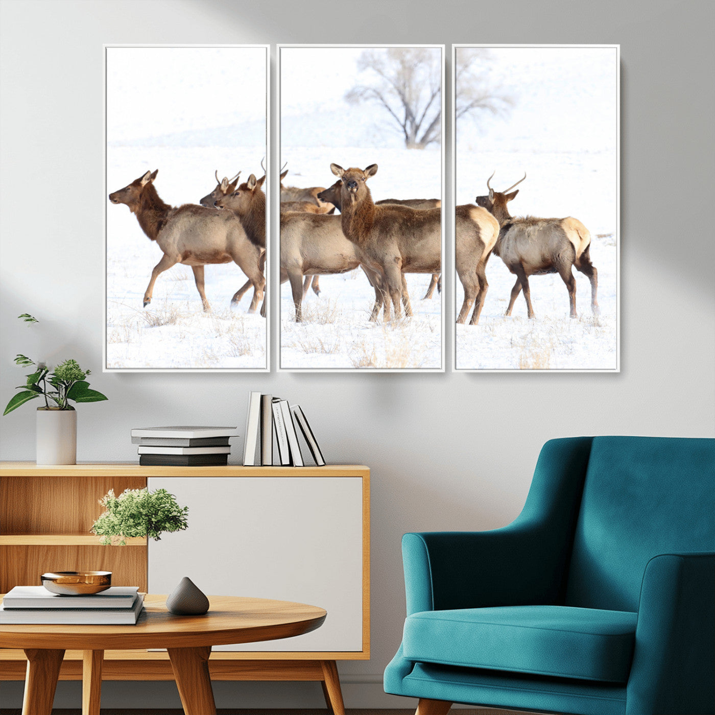 A group of elk standing on snowy terrain with a tree in the background, perfect for rustic or lodge-style winter wall decor.