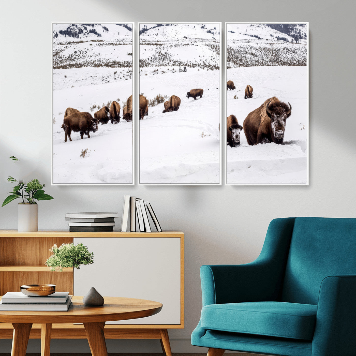 A herd of bison walking through deep snow in a mountain valley, perfect for rustic, cabin or western-themed wall decor.