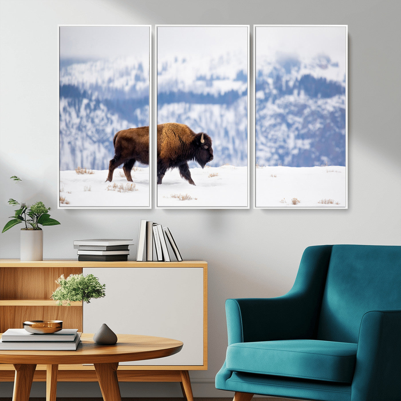 A lone bison walks across snowy ground with blue-toned mountain range behind, ideal for rustic or western farmhouse interiors.