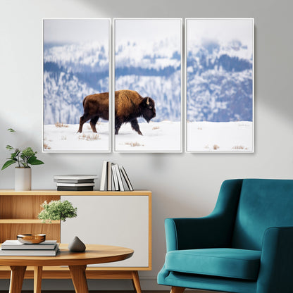 A lone bison walks across snowy ground with blue-toned mountain range behind, ideal for rustic or western farmhouse interiors.