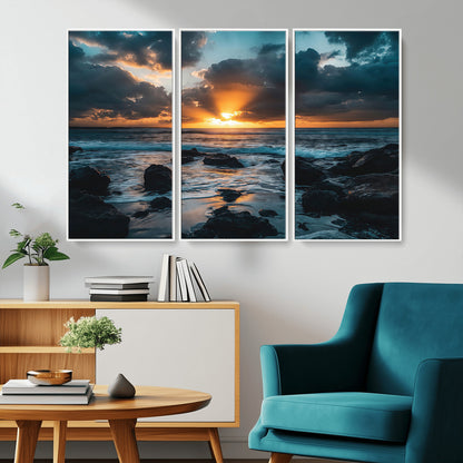 An awe-inspiring sunset over the ocean with rays of light piercing through dramatic clouds, creating a beautiful seascape with rocks in the foreground.