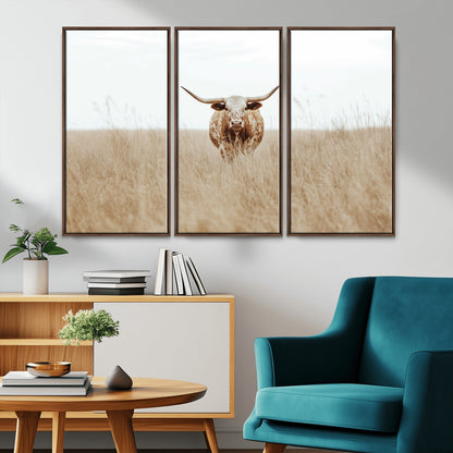Texas Longhorn bull standing alone in dry grass with neutral tones, ideal for rustic western or cowboy-themed wall decor.
