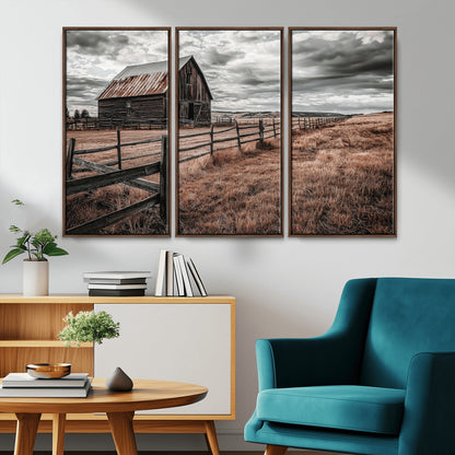 Framed canvas of a rustic barn under a moody sky with weathered fence and dark fields, ideal for farmhouse or rural-style wall decor.