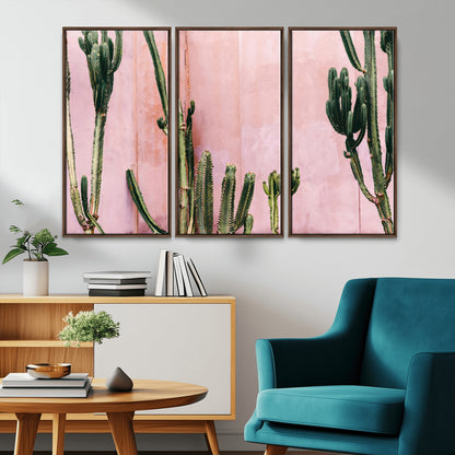 Framed canvas of tall green cacti against a soft pink wall, ideal for modern desert or colorful southwest-inspired home decor.