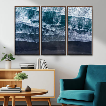 Canvas of aerial ocean waves crashing onto a black sand beach in moody tones, ideal for modern coastal or minimalist home decor.