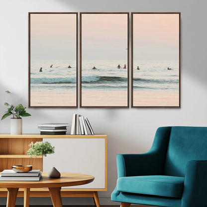 Dreamy photo of surfers waiting on soft pastel waves under a pink sunset sky, ideal for soft coastal minimalist or serene ocean-themed home decor.